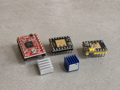 A4988, TMC2209 and ATD5833 stepper driver modules with their heatsinks centred on an electronics workbench