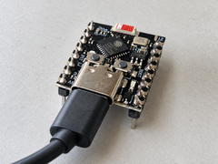NZN ESP32-C3 SuperMini with pre-soldered headers and a USB-C cable plugged in on a workbench
