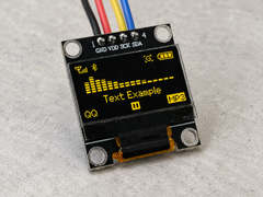 0.96 inch SSD1315 OLED showing yellow text with four jumper wires connected to its rear header