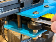 Close view of a wrench adjusting the eccentric spacer beside an installed 625ZZ POM V-slot wheel
