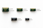 Five capacitors from the kit, 330µF 25V, 470µF 10V, 47µF 25V, 0.47µF 50V and 22µF 25V, showing the printed values and the negative stripe