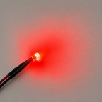 Red 3mm diffused LED illuminated against a surface showing its glow