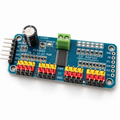 PCA9685 16-channel servo driver board at an angle, showing the 16 three-pin servo headers, screw terminal and 1000uF capacitor